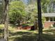 Charming home surrounded by lush trees, featuring an exterior brick wall and a well-maintained landscape at 183 Busbin Rd, Fayetteville, GA 30215