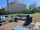 Back deck with seating, grill, and lush greenery offers a serene outdoor experience at 1600 Prospect Pl, Locust Grove, GA 30248