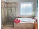 Bathroom featuring a glass enclosed shower, tub with tile surround, vanity, and decor at 1600 Prospect Pl, Locust Grove, GA 30248