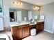 Spacious bathroom featuring double sinks, vanity, with a bright mirror and white tiled floors at 1600 Prospect Pl, Locust Grove, GA 30248