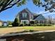 Inviting two-story brick home with manicured front lawn and American flag waving at 1600 Prospect Pl, Locust Grove, GA 30248