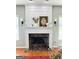 Living room fireplace with marble hearth and mantel, flanked by sconces and decorative accents at 1600 Prospect Pl, Locust Grove, GA 30248