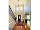 Bright foyer featuring hardwood floors and staircase leading to upper level, with a glimpse of the living room at 1600 Prospect Pl, Locust Grove, GA 30248