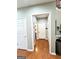 Clean hallway with hardwood floors, leading to various rooms with painted white doors at 1600 Prospect Pl, Locust Grove, GA 30248