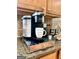 Kitchen countertop featuring modern Keurig coffee machine and granite surface at 1600 Prospect Pl, Locust Grove, GA 30248