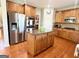 Stylish kitchen island with stainless steel appliances, ample lighting, and a hardwood floor at 1600 Prospect Pl, Locust Grove, GA 30248