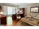 Cozy living room featuring hardwood floors, a comfortable sofa, and a stylish workspace at 1600 Prospect Pl, Locust Grove, GA 30248