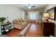 Bright living room with hardwood floors, love seat, ceiling fan, and decor at 1600 Prospect Pl, Locust Grove, GA 30248