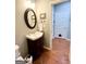 Stylish powder room with a charming vanity, hardwood flooring, and updated fixtures at 1600 Prospect Pl, Locust Grove, GA 30248