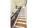 Elegant staircase featuring hardwood steps and black railings, leading to the upper level at 1600 Prospect Pl, Locust Grove, GA 30248