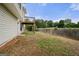 View of the home's back exterior with fenced yard, landscaping and grassy area at 8103 Rhodes Way, Riverdale, GA 30274