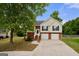 Beautiful two-story home with a two-car garage, brick accents, and mature shade tree at 8103 Rhodes Way, Riverdale, GA 30274