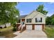 Charming home with manicured lawn, two-car garage, brick accents, and mature shade tree at 8103 Rhodes Way, Riverdale, GA 30274