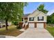 Inviting two-story home with two-car garage, complemented by a lush lawn and mature tree at 8103 Rhodes Way, Riverdale, GA 30274