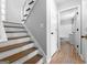 Hallway featuring a staircase, wood-look floors, and a view of the bathroom at 8103 Rhodes Way, Riverdale, GA 30274