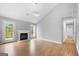 Open living room featuring hardwood floors, a fireplace, access to back deck, and natural light at 8103 Rhodes Way, Riverdale, GA 30274