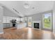 Spacious living room with a fireplace, modern lighting, wood floors, and an open concept kitchen at 8103 Rhodes Way, Riverdale, GA 30274