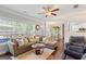 Open living room features hardwood floors, a ceiling fan, and large windows overlooking the backyard at 4402 Kady Ct, Mcdonough, GA 30252