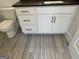 Bathroom vanity with white cabinets, stone countertop and wood-look tile flooring at 906 Winall Down Ne Rd, Atlanta, GA 30319