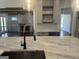 Kitchen view featuring white cabinets, open shelving, and a sleek, modern faucet at 906 Winall Down Ne Rd, Atlanta, GA 30319