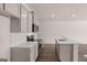 A spacious kitchen featuring white cabinets, countertops and stainless steel appliances, with an island in the center at 2761 Honey Locust Court, Loganville, GA 30052