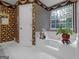 Bright bathroom featuring a soaking tub with a window and vibrant wallpaper, creating a unique and inviting space at 75 The Farm Rd, Mcdonough, GA 30252