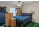 Cluttered bedroom with a ceiling fan, a window, moving boxes and a bed; ready to be transformed into a cozy retreat at 75 The Farm Rd, Mcdonough, GA 30252