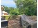 Outdoor wooden deck with a covered grill overlooking a private wooded area at 75 The Farm Rd, Mcdonough, GA 30252
