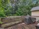 Spacious wooden deck with a covered grill overlooking a wooded area at 75 The Farm Rd, Mcdonough, GA 30252