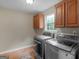 Well-equipped laundry room with modern washer and dryer units, and ample cabinet space at 75 The Farm Rd, Mcdonough, GA 30252