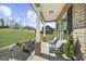 Relaxing covered porch featuring comfortable seating with a view of the landscaped yard at 924 Bryson Lake Cir, Douglasville, GA 30134