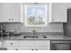 Modern kitchen featuring a stainless steel sink, granite countertops, and white cabinets at 924 Bryson Lake Cir, Douglasville, GA 30134