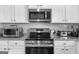 Modern kitchen featuring stainless steel appliances, granite countertops, and white cabinets at 924 Bryson Lake Cir, Douglasville, GA 30134