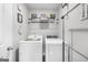 Laundry room with modern washer and dryer and overhead shelving for storage at 924 Bryson Lake Cir, Douglasville, GA 30134