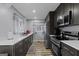 Well-lit kitchen features stainless steel appliances, white quartz countertops, dark cabinets, and wood floors at 3727 Calmer Cir, East Point, GA 30344