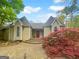 Inviting home exterior featuring a striking red door, well-manicured landscaping, and a paved pathway at 100 Little Creek Dr, Sharpsburg, GA 30277