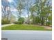 Charming home nestled among mature trees, boasting a well-manicured front lawn and inviting curb appeal at 100 Little Creek Dr, Sharpsburg, GA 30277