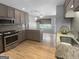 Open kitchen features stainless steel appliances, stone countertops and wood flooring at 100 Little Creek Dr, Sharpsburg, GA 30277