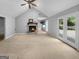 Spacious living room features a stone fireplace, vaulted ceiling and access to a private deck at 100 Little Creek Dr, Sharpsburg, GA 30277