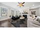 Well-lit living room with modern furniture, a stone fireplace, and large windows providing ample natural light at 1341 Rosen Rd, Brookhaven, GA 30319