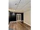 View of basement with new flooring, drop ceiling, and doors leading to the backyard at 149 Wimberly Way, Powder Springs, GA 30127