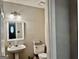 Bathroom features pedestal sink, lighting, and white toilet at 149 Wimberly Way, Powder Springs, GA 30127