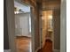 Hallway with hardwood flooring that leads to a bathroom and living room with a ceiling fan at 149 Wimberly Way, Powder Springs, GA 30127