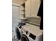 Bright laundry room featuring a washer and dryer combo, overhead cabinets, and window at 149 Wimberly Way, Powder Springs, GA 30127