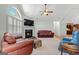 Cozy living room with a fireplace, vaulted ceilings, ceiling fan, and views into the kitchen at 406 Kenley Ct, Mcdonough, GA 30253