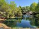 Scenic pond featuring a fountain, complemented by trees and landscaping with residences beyond at 406 Kenley Ct, Mcdonough, GA 30253