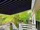 View of the retractable awning over the deck with lush green surroundings at 3870 Michaels Creek Ct, Loganville, GA 30052