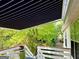 View of the retractable awning over the deck with lush green surroundings at 3870 Michaels Creek Ct, Loganville, GA 30052