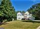 Beautiful two-story home with a well-maintained lawn and mature trees surrounding the property at 3870 Michaels Creek Ct, Loganville, GA 30052