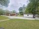 Wide-open backyard with a large deck, storage building and concrete patio with manicured lawn at 103 Belair Ln, Stockbridge, GA 30281